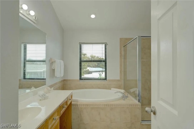 bathroom with vanity and shower with separate bathtub