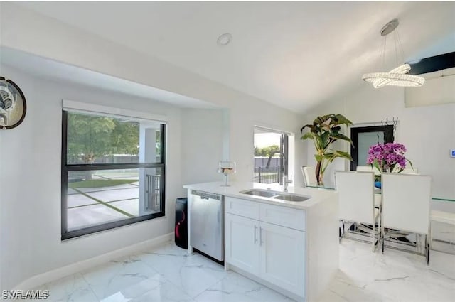 kitchen featuring decorative light fixtures, lofted ceiling, stainless steel dishwasher, sink, and white cabinetry