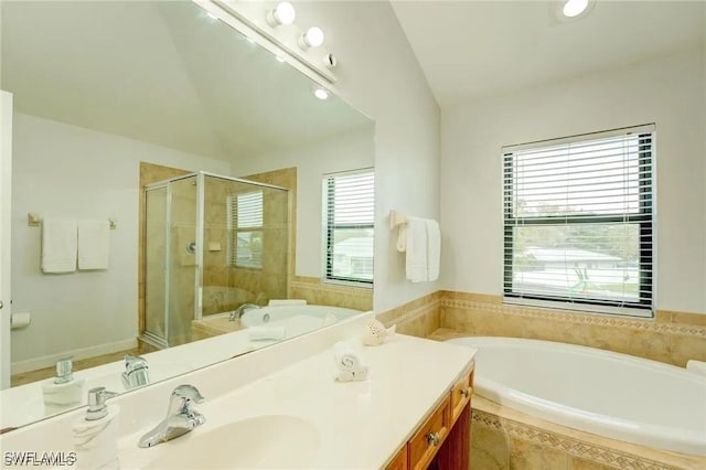 bathroom featuring vanity, vaulted ceiling, and independent shower and bath