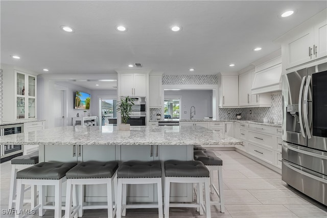 kitchen with white cabinetry, sink, appliances with stainless steel finishes, and a breakfast bar area