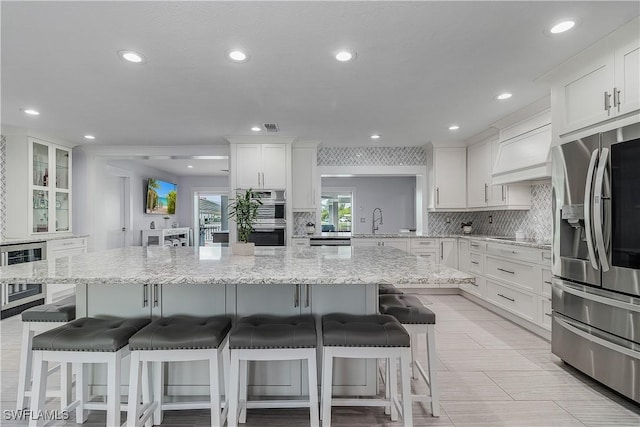 kitchen featuring stainless steel appliances, sink, a breakfast bar area, and white cabinets