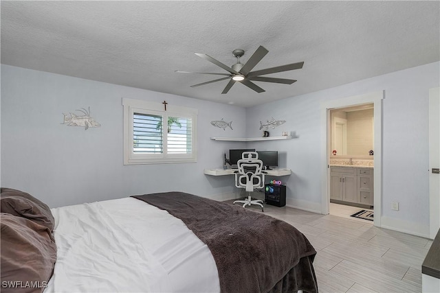 bedroom featuring ceiling fan, ensuite bath, and a textured ceiling