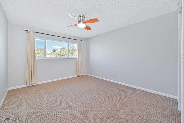 carpeted spare room featuring a textured ceiling and ceiling fan