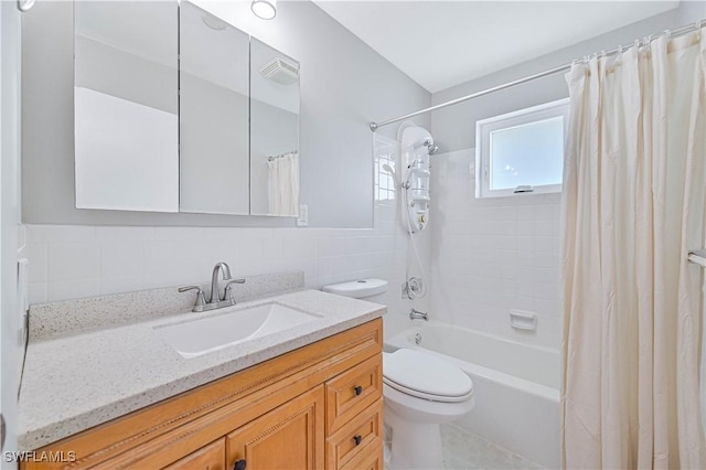 full bathroom with tile walls, vanity, toilet, and shower / tub combo with curtain