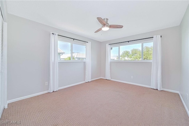 empty room featuring light colored carpet and ceiling fan