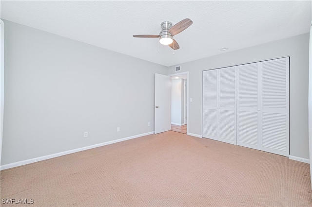 unfurnished bedroom featuring ceiling fan, a closet, carpet floors, and a textured ceiling