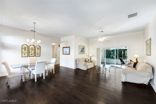 dining area with ceiling fan with notable chandelier and dark hardwood / wood-style flooring