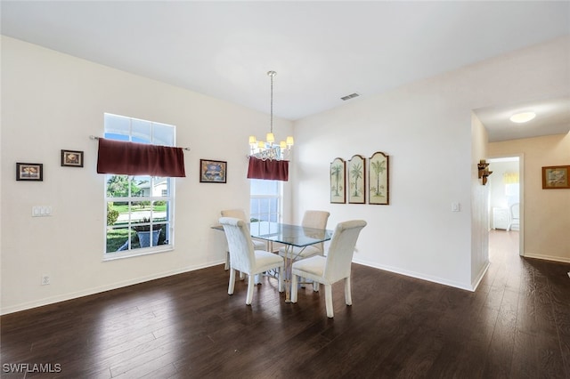 dining space with dark hardwood / wood-style flooring and a chandelier