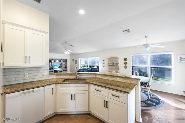 kitchen featuring white dishwasher, white cabinetry, kitchen peninsula, and sink