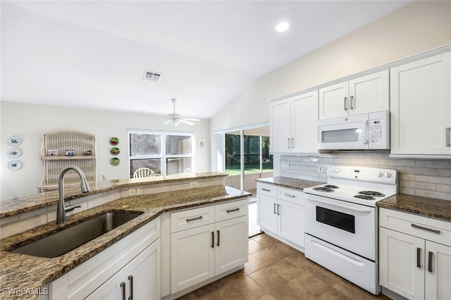 kitchen with white appliances, white cabinetry, vaulted ceiling, and sink