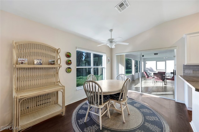 dining room with ceiling fan, dark wood-type flooring, and vaulted ceiling