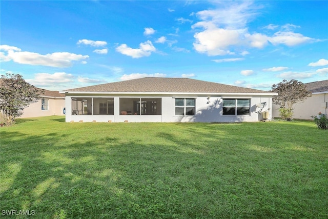 rear view of house with a yard and a sunroom