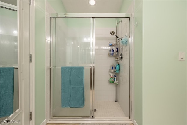 bathroom featuring a shower with shower door