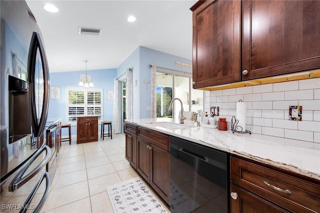 kitchen with sink, tasteful backsplash, light stone counters, pendant lighting, and appliances with stainless steel finishes