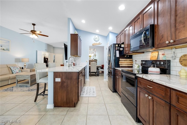 kitchen with a kitchen bar, tasteful backsplash, lofted ceiling, and black appliances