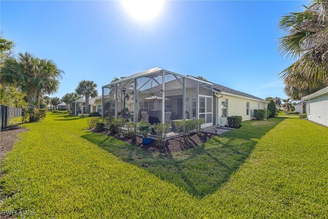 back of property with a lanai and a lawn