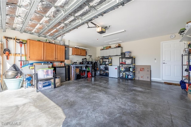 garage featuring white fridge and a garage door opener