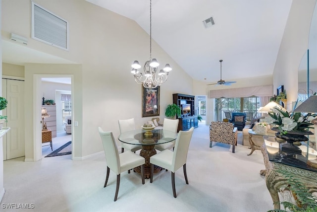 dining space featuring high vaulted ceiling, light colored carpet, and ceiling fan with notable chandelier