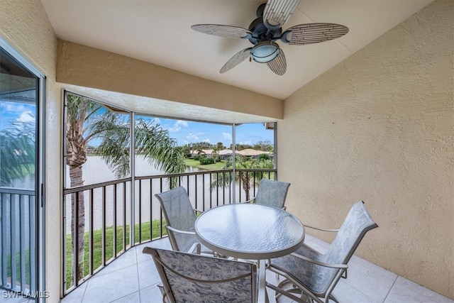 sunroom / solarium featuring ceiling fan, a water view, and vaulted ceiling