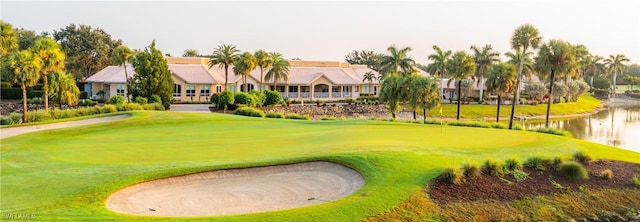 view of home's community featuring a water view, golf course view, and a yard