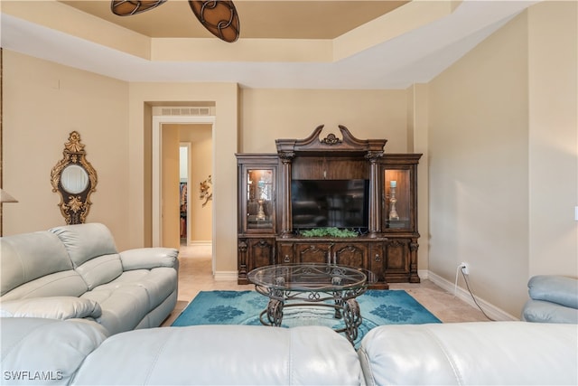 tiled living room featuring a raised ceiling