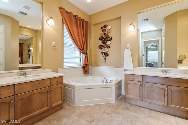 bathroom with tile patterned floors, a tub to relax in, and vanity