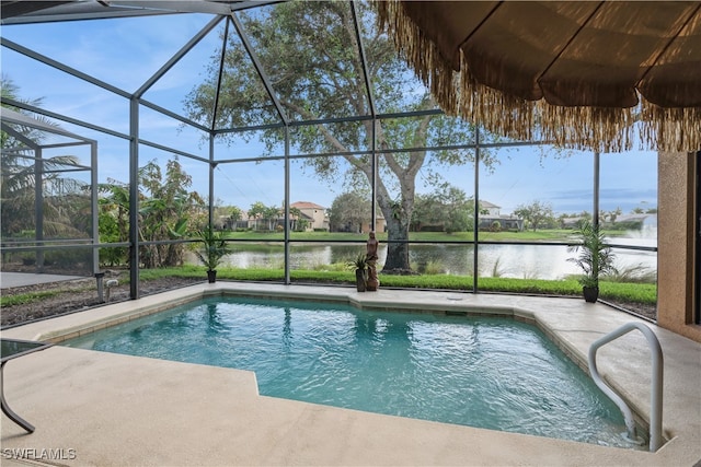 view of swimming pool with glass enclosure, a water view, and a patio