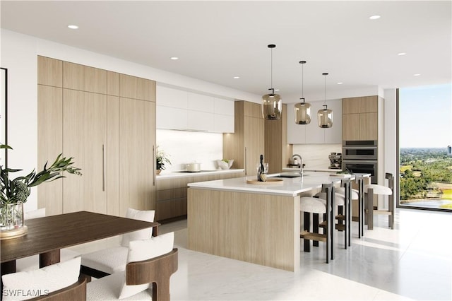 5100 Baybridge Blvd Unit 1901, Estero, FL 33928 - kitchen with modern cabinets, a breakfast bar, light countertops, an island with sink, and stainless steel double oven