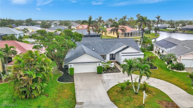 view of front of home featuring a front yard, a garage, and a water view