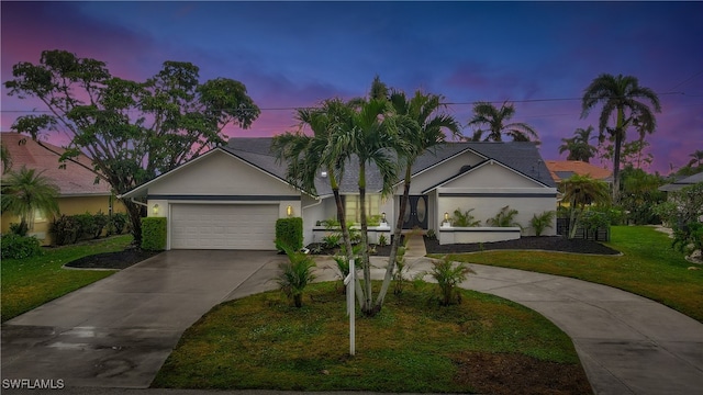 single story home featuring a lawn and a garage