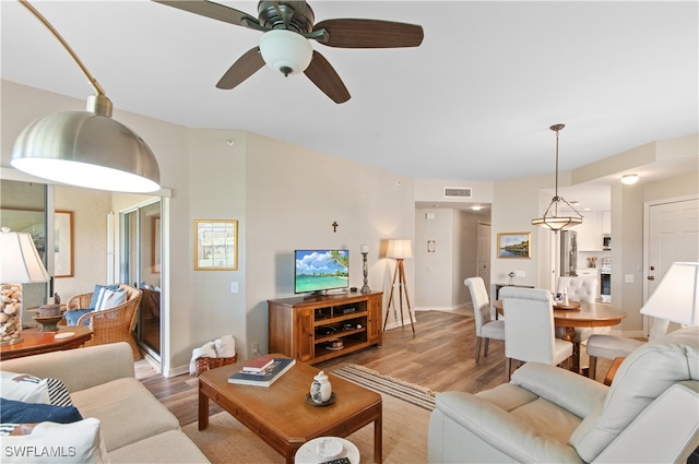 living room with ceiling fan and light wood-type flooring