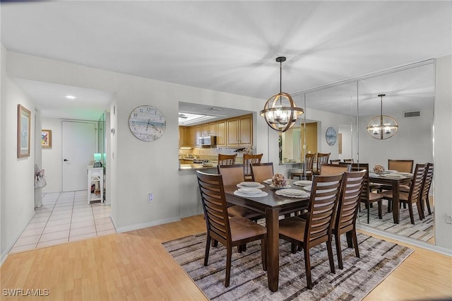 dining area with a chandelier and light hardwood / wood-style flooring