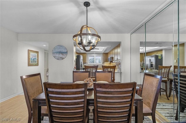 dining room with light hardwood / wood-style flooring and a chandelier