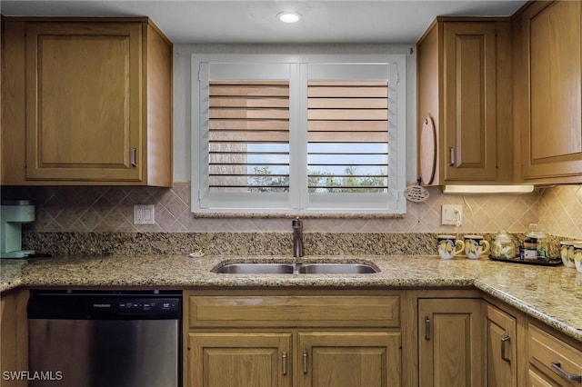 kitchen with dishwasher, tasteful backsplash, light stone counters, and sink