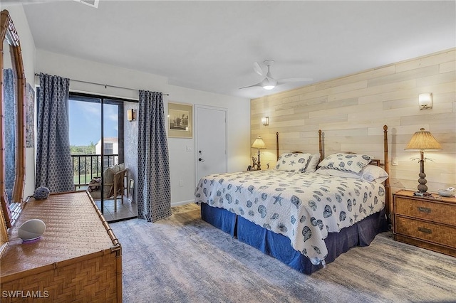 bedroom with hardwood / wood-style floors, ceiling fan, access to exterior, and wooden walls