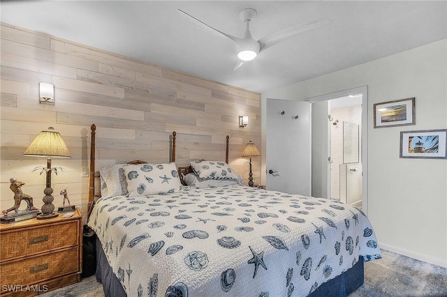 carpeted bedroom featuring ceiling fan and wood walls