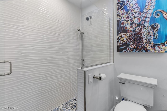 bathroom featuring toilet and a tile shower