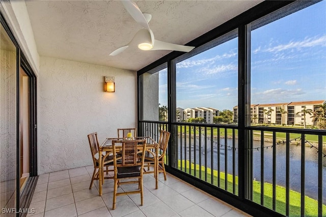 sunroom / solarium with a water view and ceiling fan