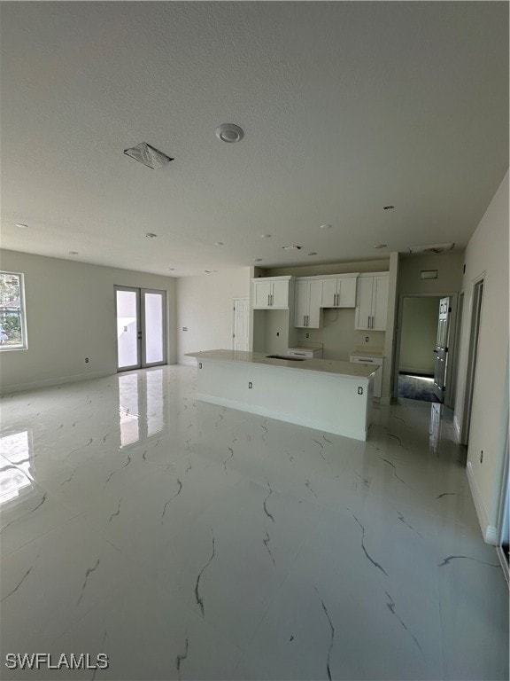 unfurnished living room featuring a textured ceiling and a wealth of natural light