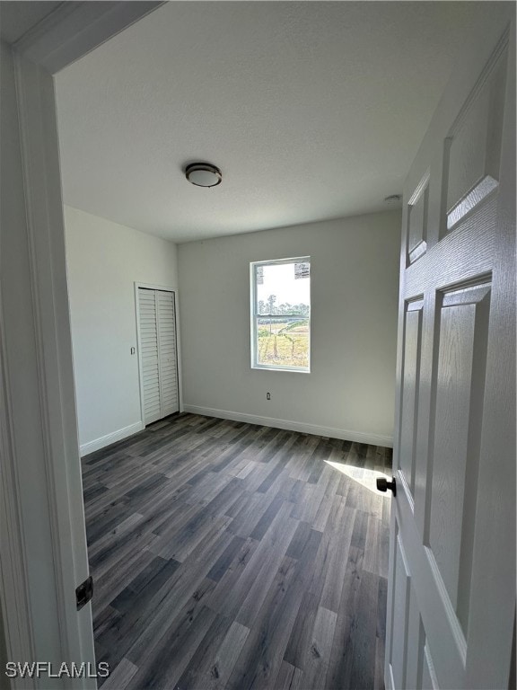 unfurnished bedroom with dark hardwood / wood-style flooring