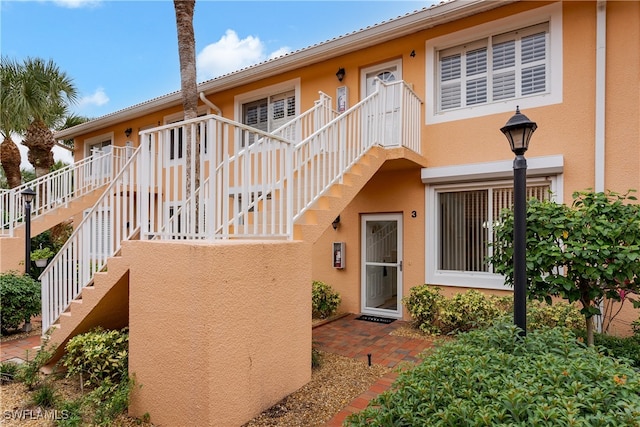 view of front of home with stucco siding and stairs