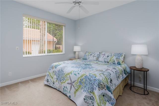 bedroom featuring baseboards, a ceiling fan, and light colored carpet