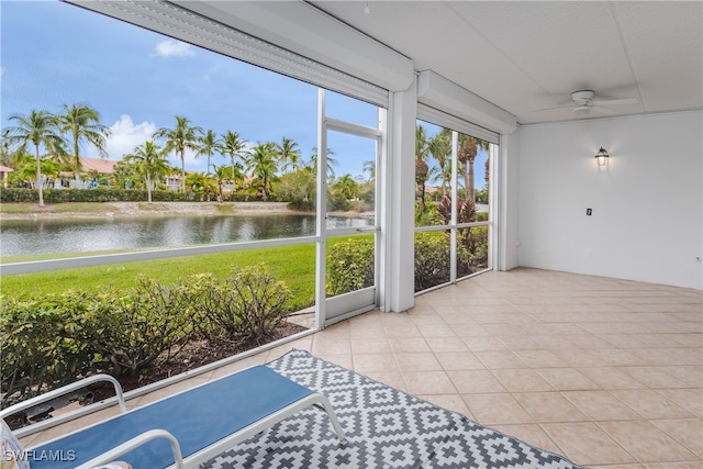 unfurnished sunroom featuring a water view and ceiling fan