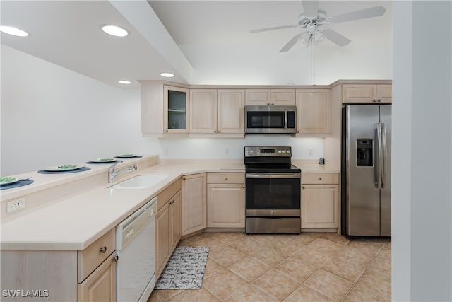 kitchen with stainless steel appliances, recessed lighting, light countertops, glass insert cabinets, and a sink