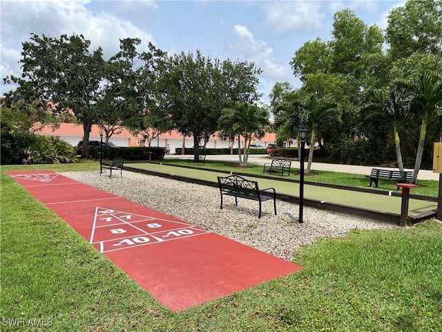 view of community with shuffleboard and a yard