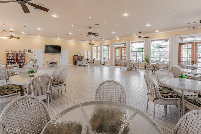 dining space with light wood finished floors, ceiling fan, crown molding, french doors, and recessed lighting