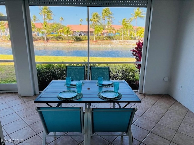 tiled dining area with a water view and a wealth of natural light