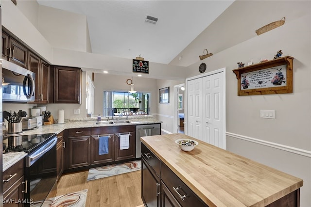 kitchen featuring wood counters, appliances with stainless steel finishes, dark brown cabinets, sink, and light hardwood / wood-style floors