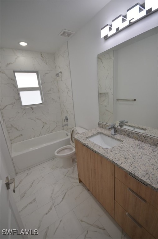 full bathroom featuring vanity, tiled shower / bath combo, and toilet