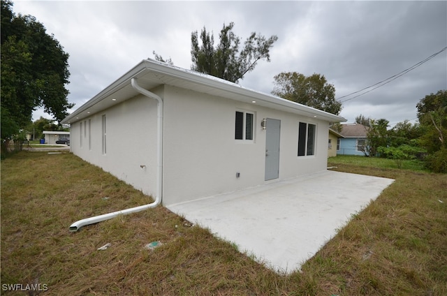 rear view of house featuring a yard and a patio